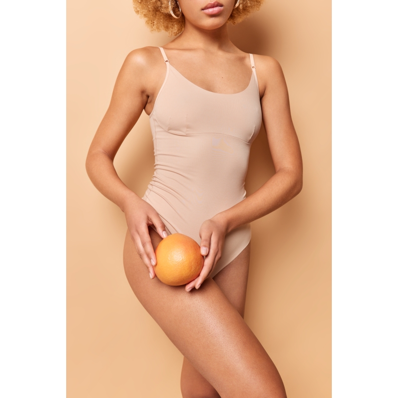 vertical-shot-faceless-healthy-woman-brown-underwear-holds-orange-body-has-clean-healthy-skin-without-cellulite-slender-legs-demonstrates-perfect-figure-after-liposuction-poses-indoor.jpg